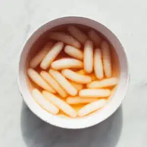 Korean rice cakes soaking in warm water in a bowl