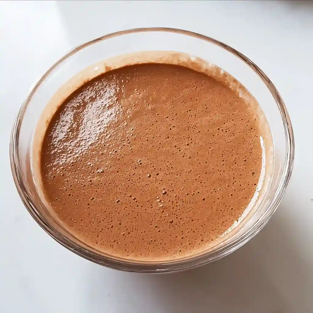 Blended cottage cheese and cocoa mixture in a glass bowl for cottage cheese fudge