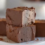Cottage cheese fudge squares stacked on a white plate with a creamy and rich texture